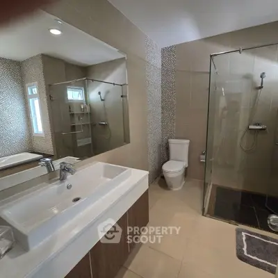 Modern bathroom with glass shower and stylish sink in contemporary home.