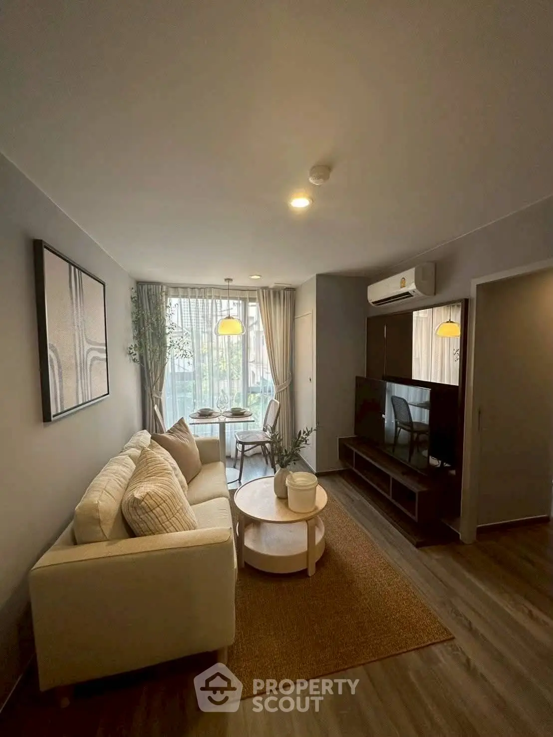 Chic modern living room with cozy sofa, stylish decor, and natural light from large window.