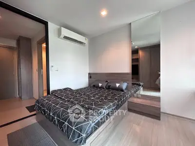 Modern bedroom with stylish decor and large mirror in a contemporary apartment.
