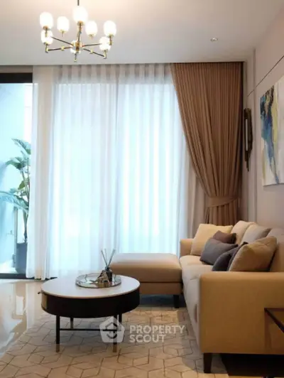 Elegant living room with modern decor and large window for natural light.