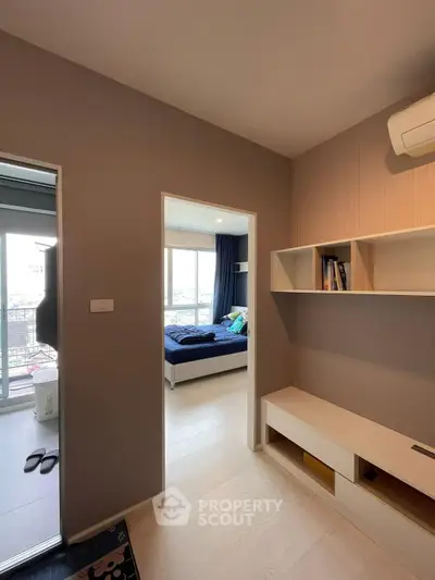 Modern apartment interior with bedroom and hallway, featuring built-in shelves and air conditioning.