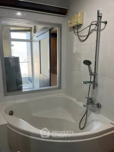 Modern bathroom with corner bathtub and shower, featuring a window with a scenic view.