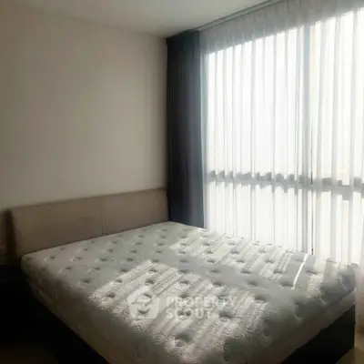 Bright bedroom with large window and modern bed, perfect for relaxation and comfort.