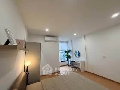 Modern bedroom with minimalist decor, featuring a cozy bed, stylish desk, and ample natural light.