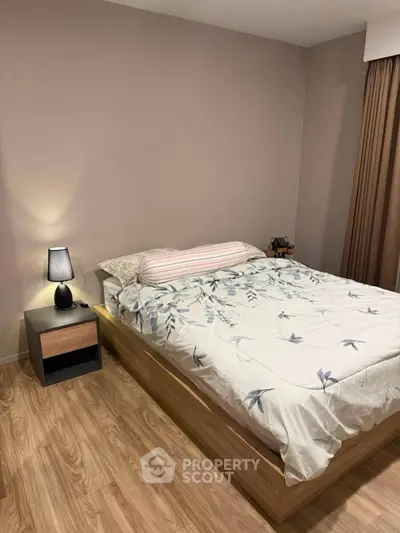 Cozy bedroom with wooden flooring and modern decor in a stylish apartment.