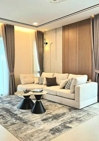 Elegant living room with modern decor, featuring a plush sofa and stylish coffee tables.