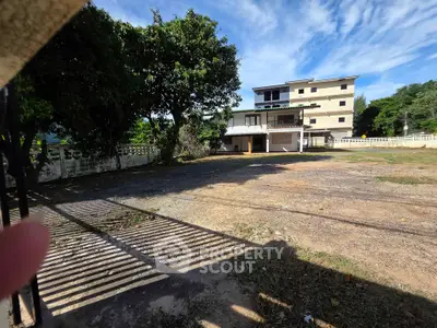 Spacious property with ample parking and lush greenery, perfect for development or investment.