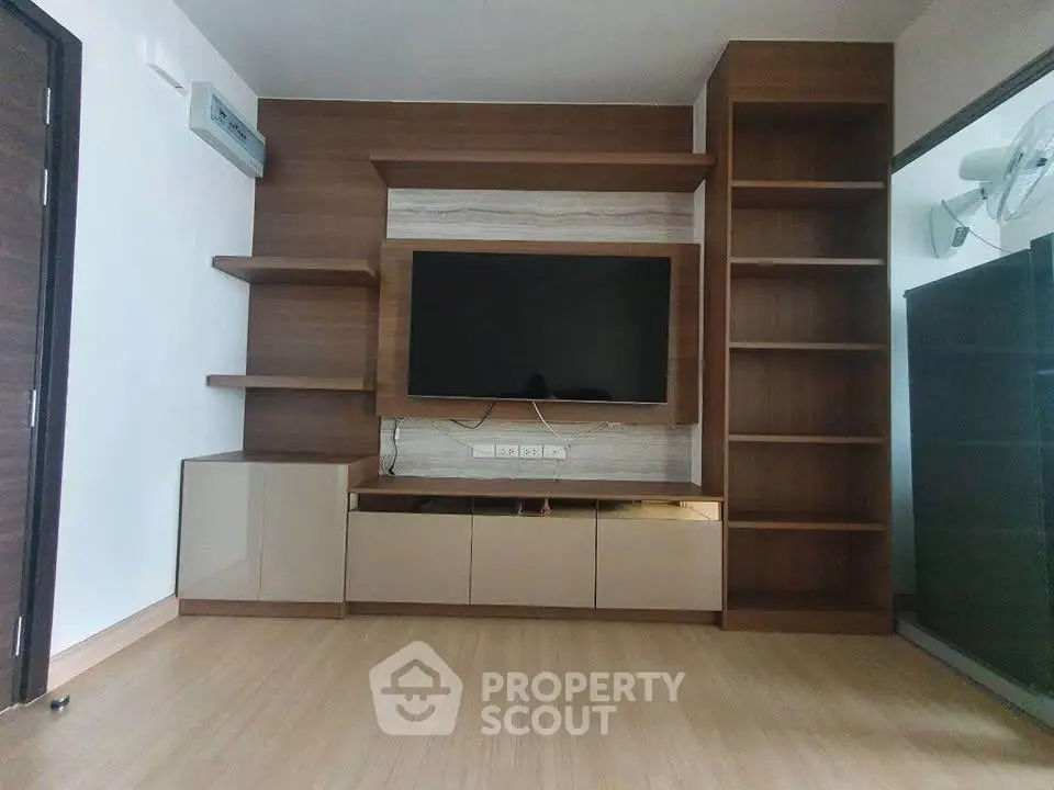 Modern living room with sleek wooden entertainment center and mounted TV, perfect for stylish urban living.