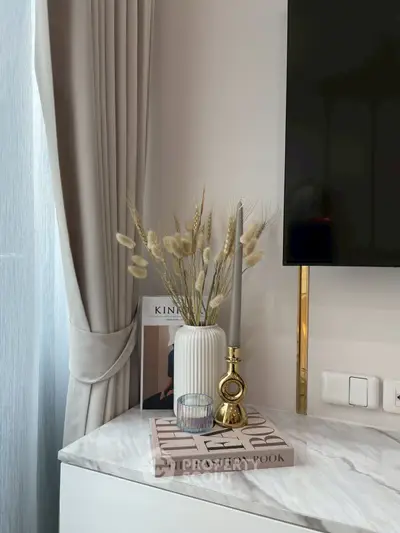 Elegant interior decor with marble surface, stylish vase, and modern candle holder.