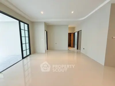 Spacious modern living room with sleek tile flooring and large windows for natural light.