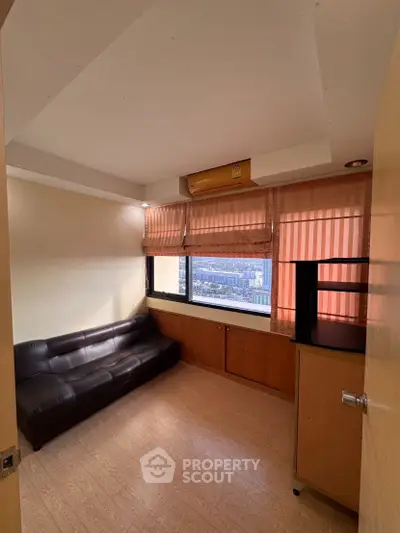 Cozy small living room with city view and leather sofa