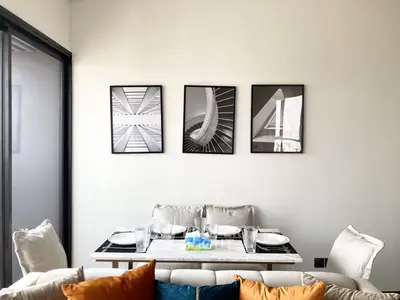 Chic modern living room with stylish sofa adorned with colorful cushions, complemented by a sleek coffee table and elegant wall art.