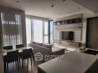 Modern living room with sleek furniture and large windows offering city views.