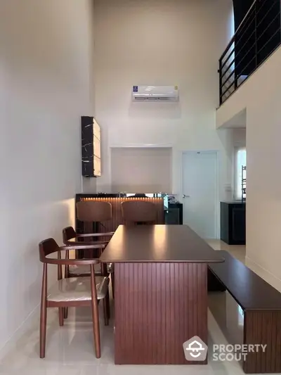 Modern dining area with sleek wooden furniture and high ceiling