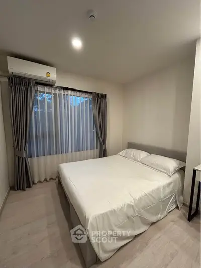 Cozy bedroom with large window and air conditioning, perfect for restful nights.