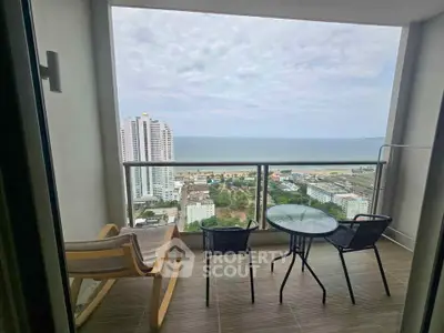 Stunning balcony view with ocean backdrop and modern seating area.