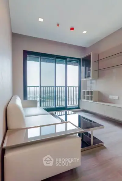 Modern living room with sleek furniture and large windows offering a stunning view.