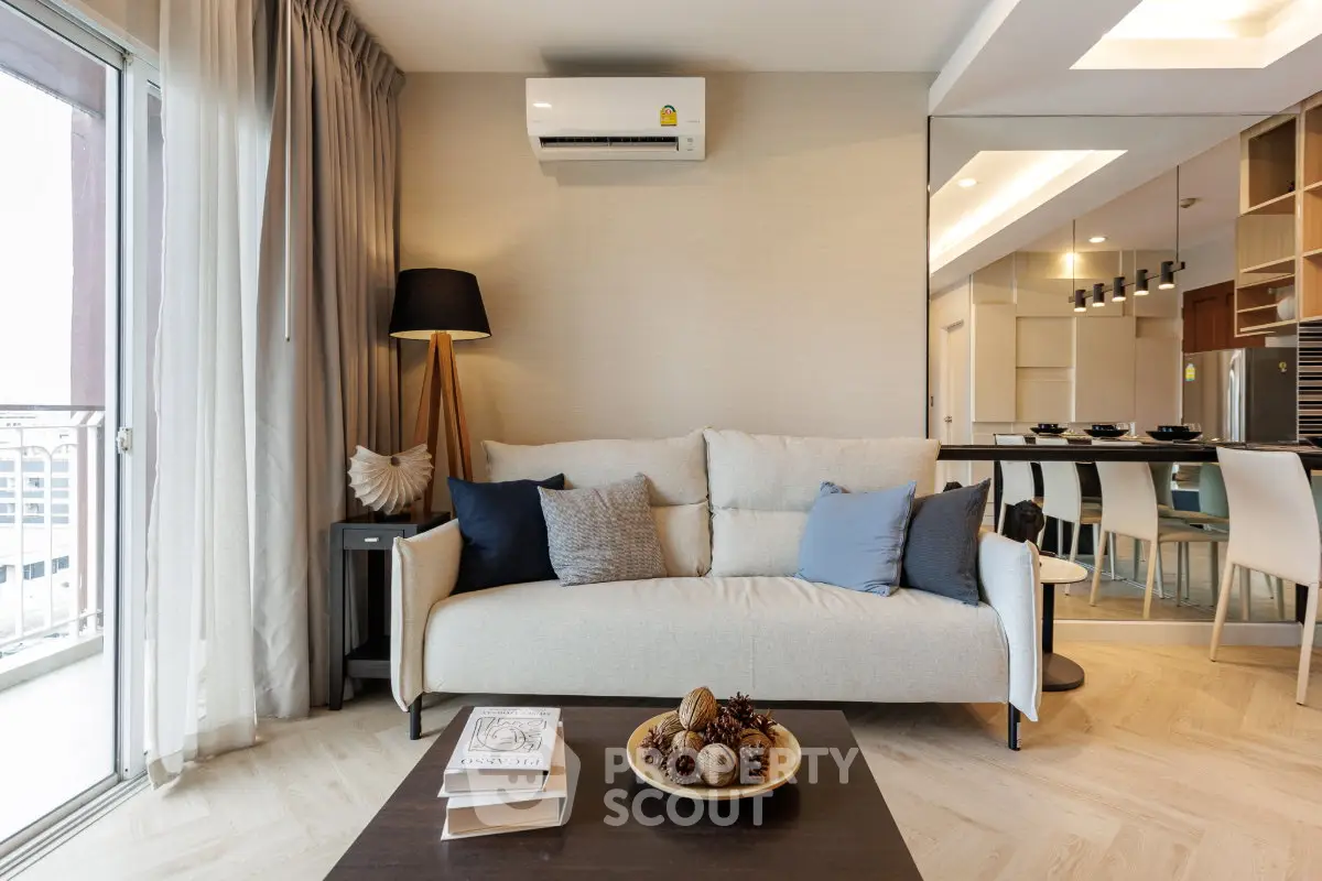 Modern living room with cozy sofa, stylish decor, and open kitchen layout
