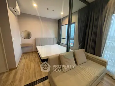 Modern bedroom with large windows and cozy sofa in a stylish apartment