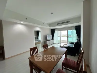 Spacious living room with dining area and balcony view in modern apartment.