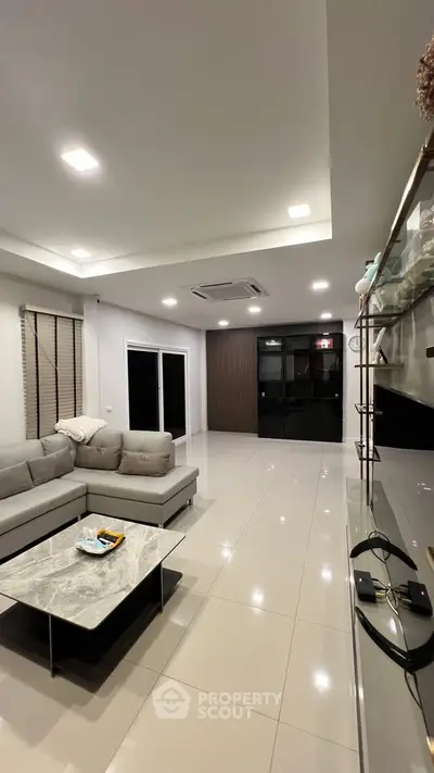 Modern living room with sleek design, featuring a comfortable sectional sofa and elegant marble coffee table.