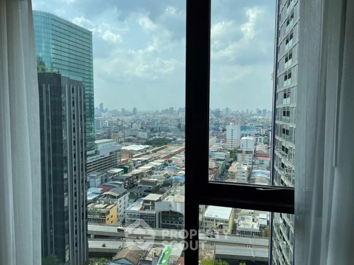 Stunning cityscape view from high-rise apartment window with urban skyline.