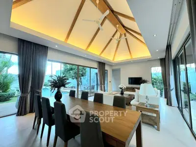 Luxurious open-plan living room with high ceilings and garden view, perfect for modern living.