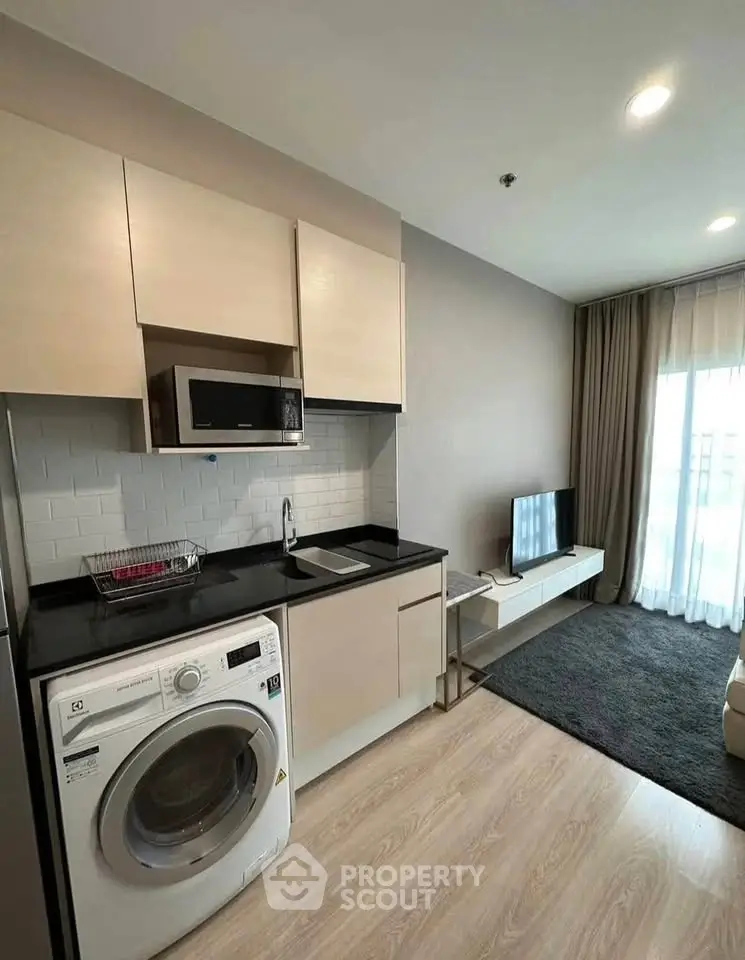 Modern apartment kitchen with washing machine and sleek cabinetry