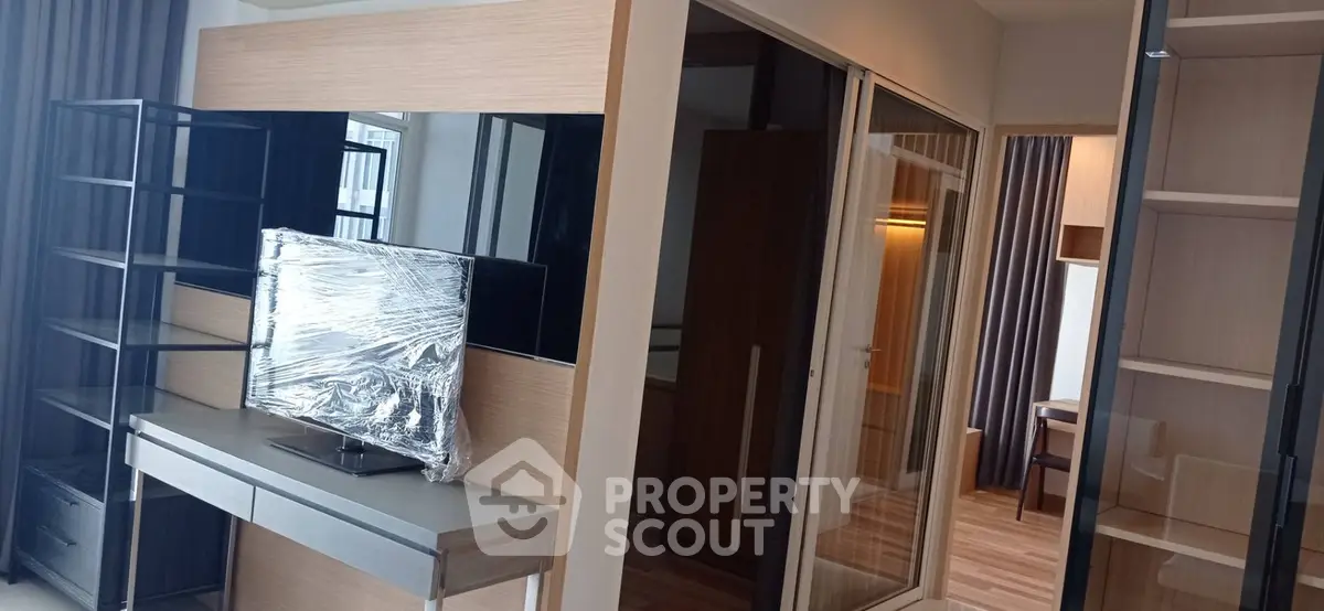 Modern living room with sleek shelving and TV setup in stylish apartment.