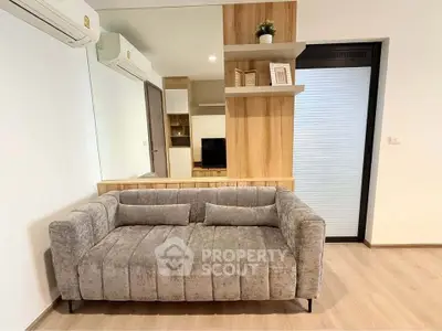 Modern living room with stylish gray sofa and wooden shelving, perfect for cozy relaxation.