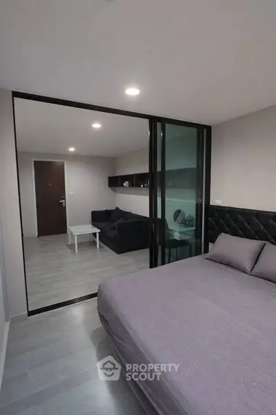 Modern bedroom with glass partition and cozy living area