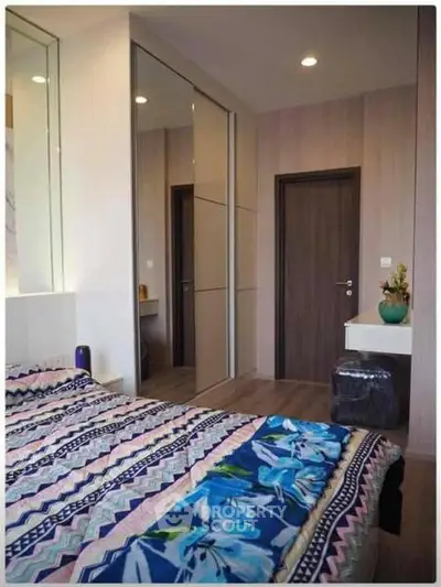 Modern bedroom with stylish decor and mirrored wardrobe doors
