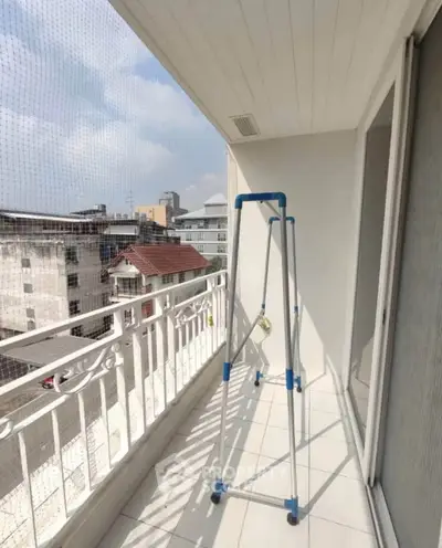 Spacious balcony with city view and safety netting, perfect for relaxation and enjoying the skyline.