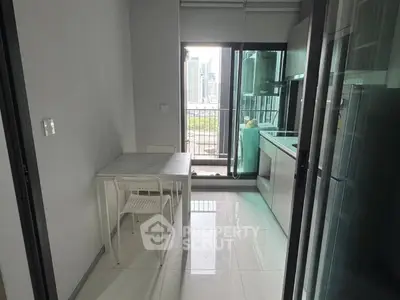 Modern kitchen with balcony view in high-rise apartment, featuring sleek design and natural light.
