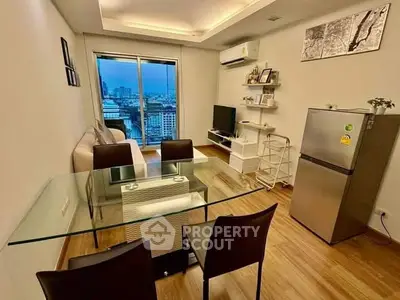 Modern living room with city view, featuring sleek furniture and open layout.