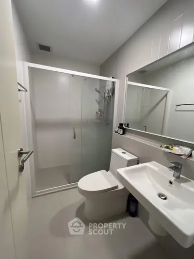 Modern bathroom with glass shower enclosure and sleek fixtures