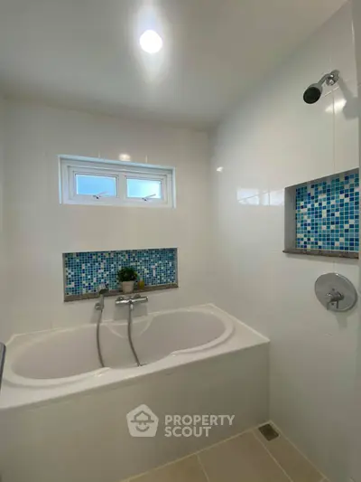 Modern bathroom with stylish bathtub and mosaic tile accents
