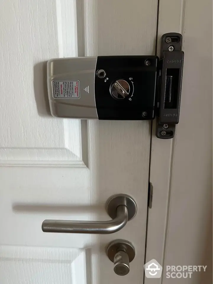 Modern door lock system on white door with sleek handle