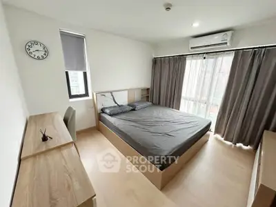 Modern bedroom with large window, stylish furniture, and natural light.