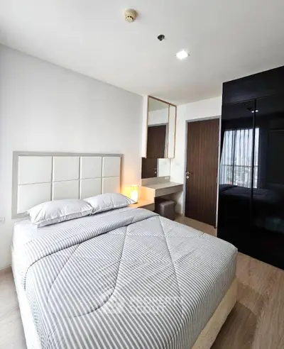 Modern bedroom with stylish decor and ample natural light, featuring a comfortable bed and sleek wardrobe.