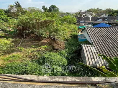 Lush green garden view with neighboring houses, perfect for nature lovers seeking tranquility.