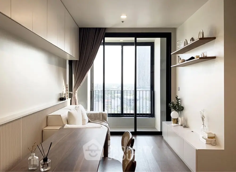 Modern living room with large window and balcony view, featuring stylish furniture and decor.