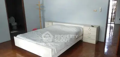 Spacious bedroom with wooden flooring and modern bed setup