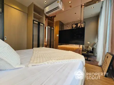 Luxurious modern bedroom with stylish decor and large TV, perfect for relaxation.