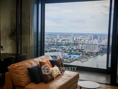 Luxurious living room with stunning city and river view from high-rise apartment.