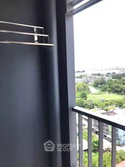 Stunning high-rise balcony view overlooking lush greenery and cityscape, perfect for urban living.