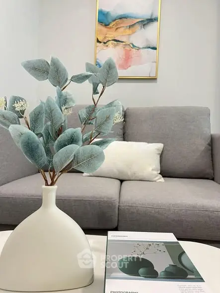 Stylish modern living room with gray sofa and decorative vase, perfect for cozy relaxation.