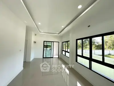 Spacious modern living room with large windows and natural light