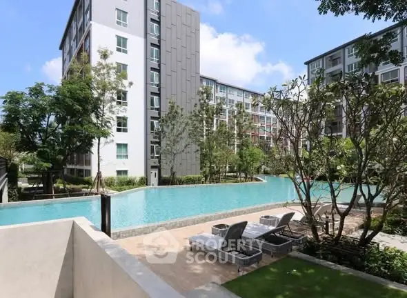 Modern apartment complex with pool and lush greenery, perfect for urban living.