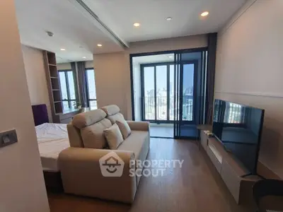 Modern living room with city view, featuring cozy sofa and large TV, perfect for relaxation.